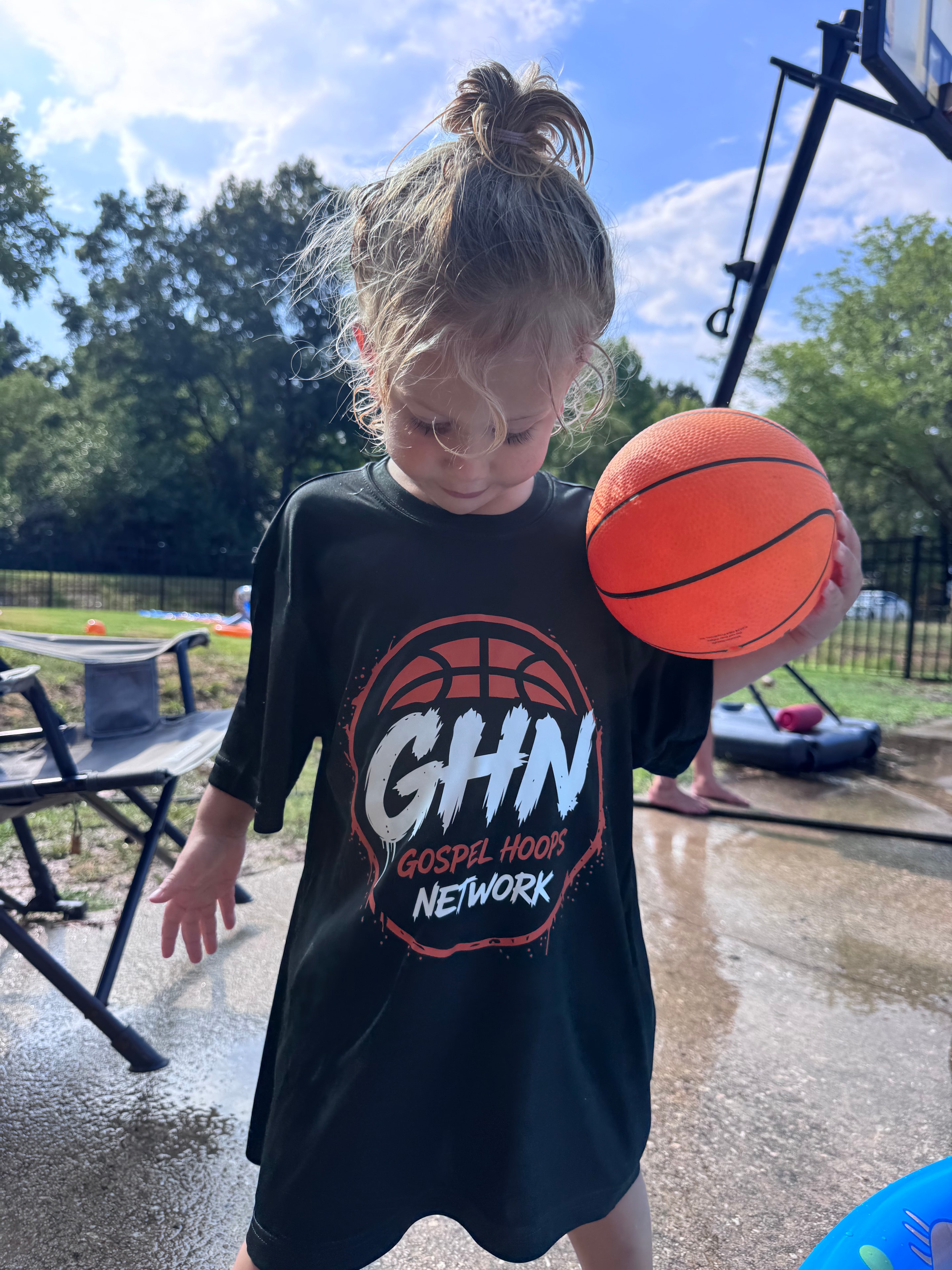 Kid holding basketball in GHN tee